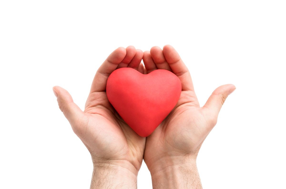 Red heart in man's hands. Health insurance or love concept 